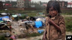 5일 인도 북부와 파키스탄에 내린 홍수로 대규모 인명 피해가 발생한 가운데, 스리나가르 지역의 한 소녀와 가족들이 임시 거처에서 물건을 건지고 있다. 