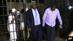  Zimbabwe's former finance minister, Ignatius Chombo, center and Kudzanai Chipanga are led to a prison truck in Harare, Zimbabwe, Nov. 25, 2017. Chombo testified that armed men in masks and uniforms abducted him from his home during the military clampdown code-named Operation Restore Legacy.