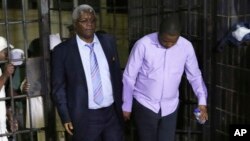  Zimbabwe's former finance minister, Ignatius Chombo, center and Kudzanai Chipanga are led to a prison truck in Harare, Zimbabwe, Nov. 25, 2017. Chombo testified that armed men in masks and