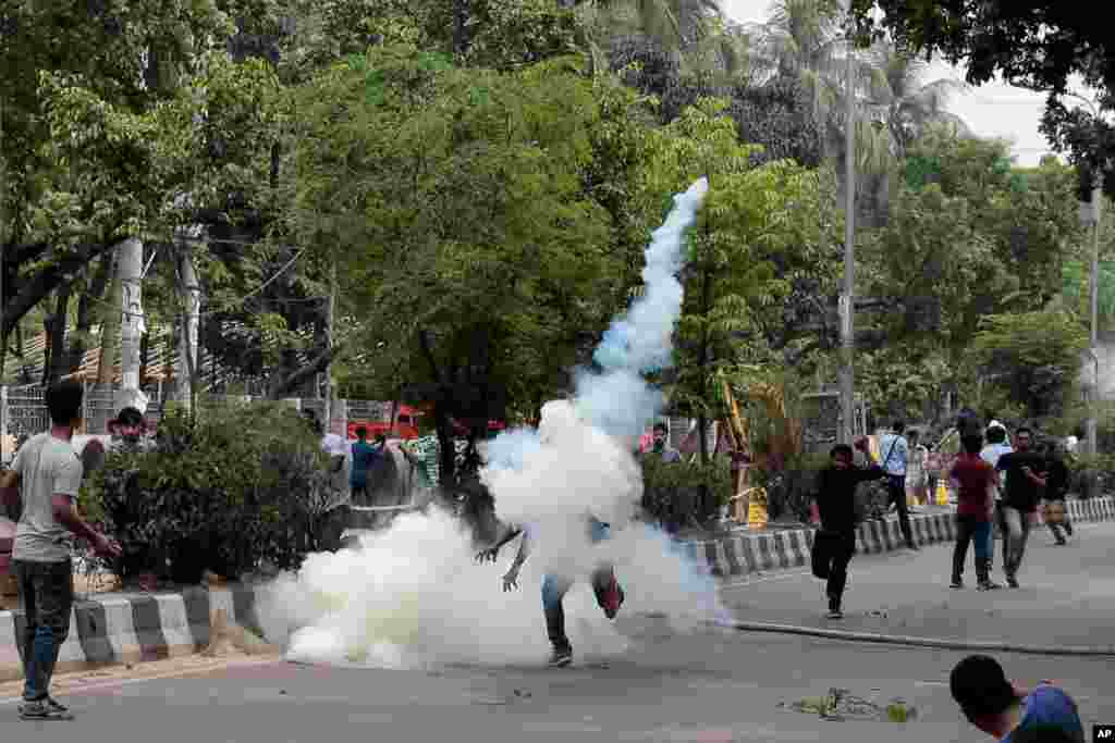 A student throws back an exploded tear gas shell at policemen during a protest for removing or reforming a quota system in government jobs in Dhaka, Bangladesh.