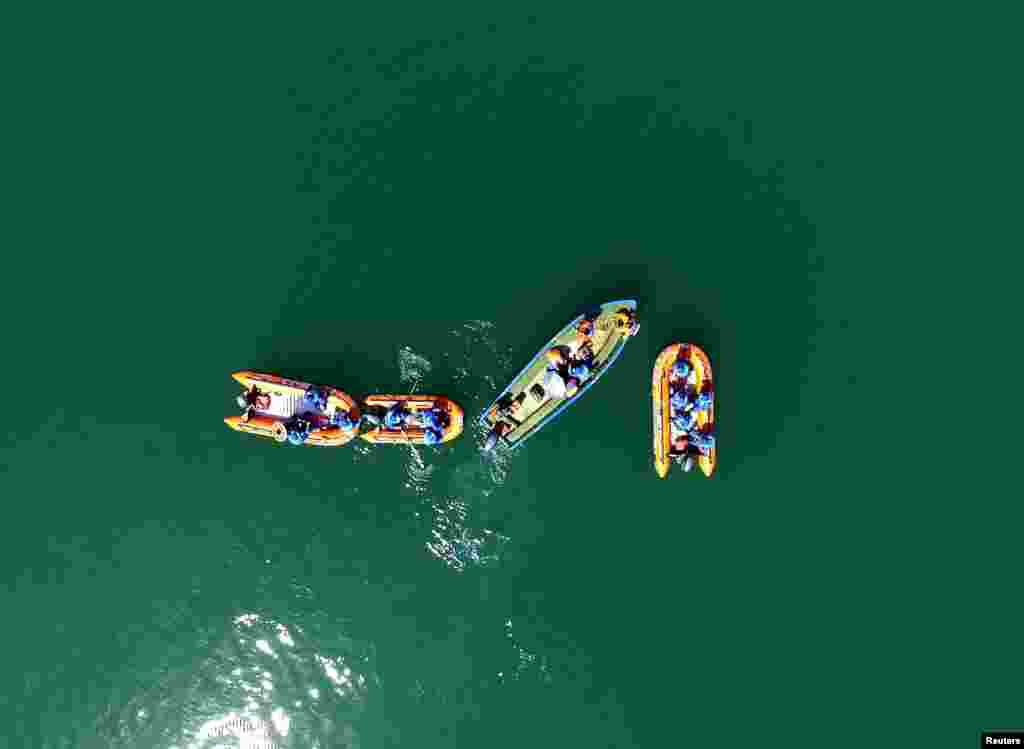 Lực lượng cứu hộ tìm kiếm người mất tích tại nơi một chiếc thuyền du ngoạn bị lật úp vì gió mạnh trên một hồ nước ở thành phố Quảng Nguyên, tỉnh Tứ Xuyên, Trung Quốc, ngày 5 tháng 6, 2016.