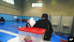 A Qatari woman cast her ballot in legislative elections, in Doha, Qatar, Oct. 2, 2021.