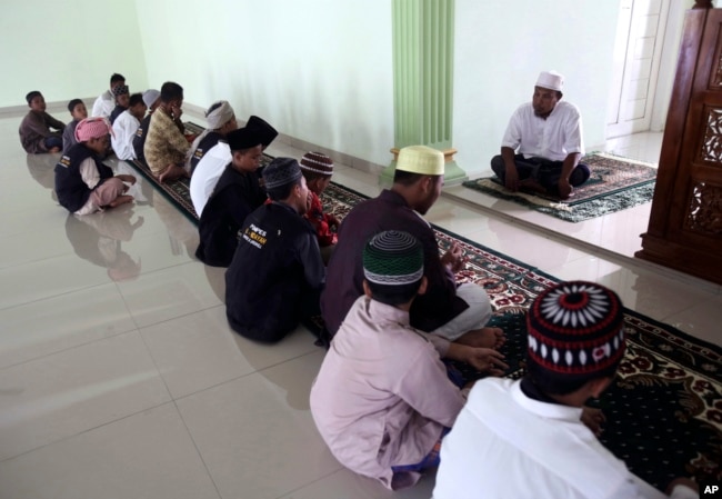 Mantan penceramah, Khairul Ghazali (atas), memberikan ceramah di Pesantren Al Hidayah, Sei Mencirim, Sumatra Utara, 22 Juli 2017. Pesantren itu didirikan untuk anak-anak tersangka pelaku teror, baik yang terbunuh atau dipenjara, untuk mencegah munculnya generasi baru militan Indonesia. (Foto: AP)