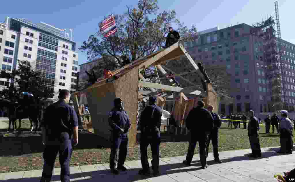 U.S. Park Police guard a structure set up by protesters overnight on McPherson Square, Sunday, Dec. 4, 2011 in Washington. Occupy DC protesters who are refusing to dismantle the unfinished wooden structure erected in the park. (AP Photo/Manuel Balce Ce