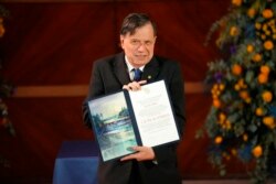 Italian physicist Giorgio Parisi shows the 2021 Nobel for Physics medal and diploma he just received during an award ceremony at La Sapienza University in Rome, Dec. 6, 2021.