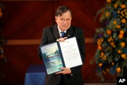 Italian physicist Giorgio Parisi shows the 2021 Nobel for Physics medal and diploma he just received during an award ceremony at La Sapienza University in Rome, Dec. 6, 2021.