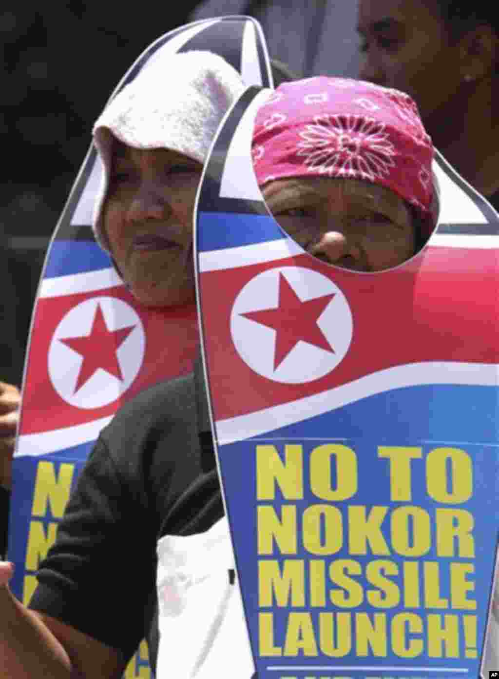 Two female protesters wearing a rocket shaped cut-out placards join a picket in protest of North Korea's rocket launch Friday, April 13, 2012 in suburban Quezon City, north of Manila, Philippines. The protesters demanded that North Korea stop any plans to