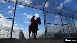 FILE - An inmate rides a wild horse as part of the Wild Horse Inmate Program ( WHIP) at Florence State Prison in Florence, Arizona.