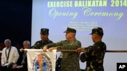 U.S. Marine Col. John Rutherford, 2nd from R, and Philippine Army Maj.Gen. Emeraldo Magnaye, 3rd from R, unfurl the joint U.S.-Philippines military exercise flag at Armed Forces of the Philippines headquarters in Manila, Philippines, on May 5, 2014.