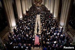 The Honor Guard carries the casket of former president George Herbert Walker Bush down the center isle following a memorial ceremony at the National Cathedral in Washington, Dec. 5, 2018.