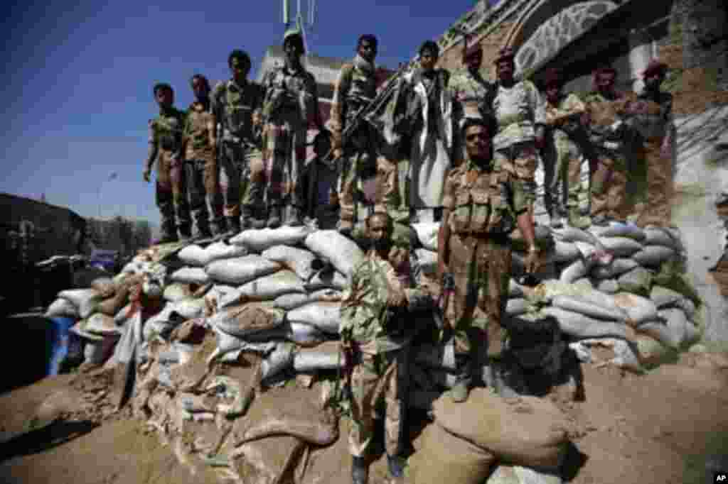 Defected army soldiers backing anti-government protesters stand guard on sandbags as protesters march to demand the release of detained fellow protesters in Sanaa January 26, 2012. REUTERS/Khaled Abdullah (YEMEN - Tags: POLITICS CIVIL UNREST MILITARY)