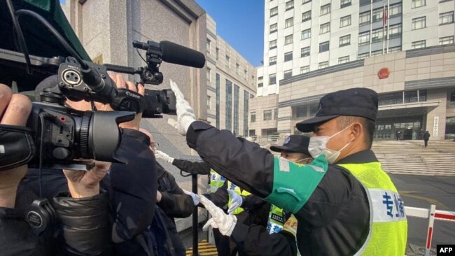 一名警察挡住记者的镜头阻止拍摄审讯公民记者张展的上海浦东新区法院外景。（2021年12月28日）