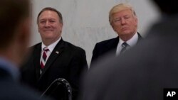 FILE - President Donald Trump, accompanied by then-CIA Director-designate Mike Pompeo, left, waits to speak at the Central Intelligence Agency in Langley, Virginia, Jan. 21, 2017.
