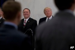 President Donald Trump, accompanied by CIA Director-designate Mike Pompeo, left, waits to speak at the Central Intelligence Agency in Langley, Virginia, Jan. 21, 2017.