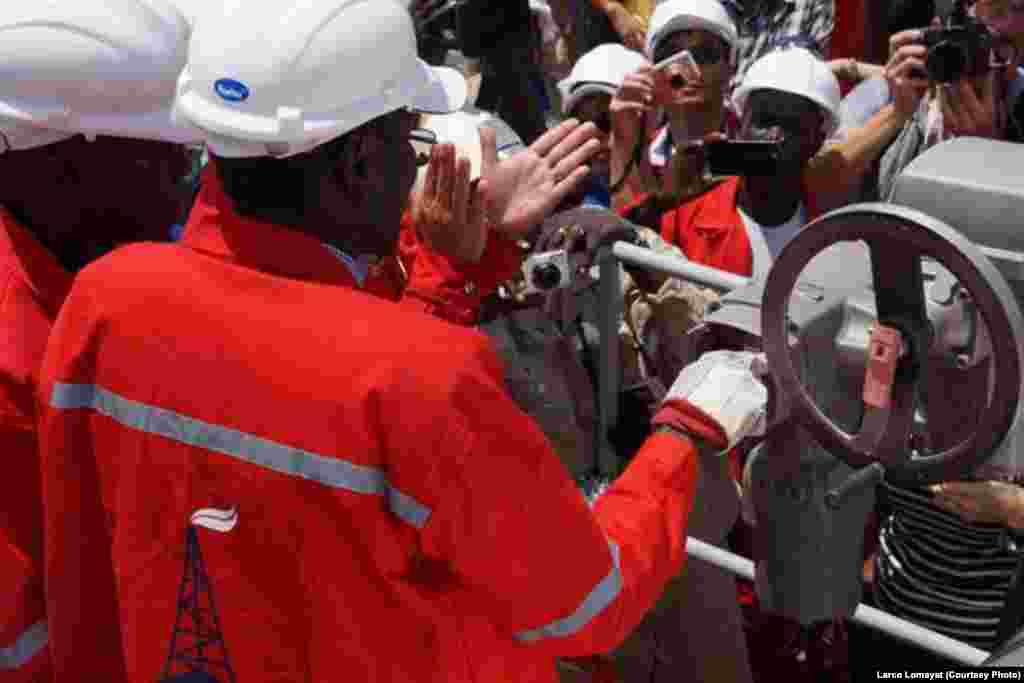 South Sudanese Minister for Petroleum and Mining Oil Minister Stephen Dhieu Dau pushes a button Sunday, May 5, 2013, to resume production at the Paloch oil field in Upper Nile state, after a 16-month hiatus.