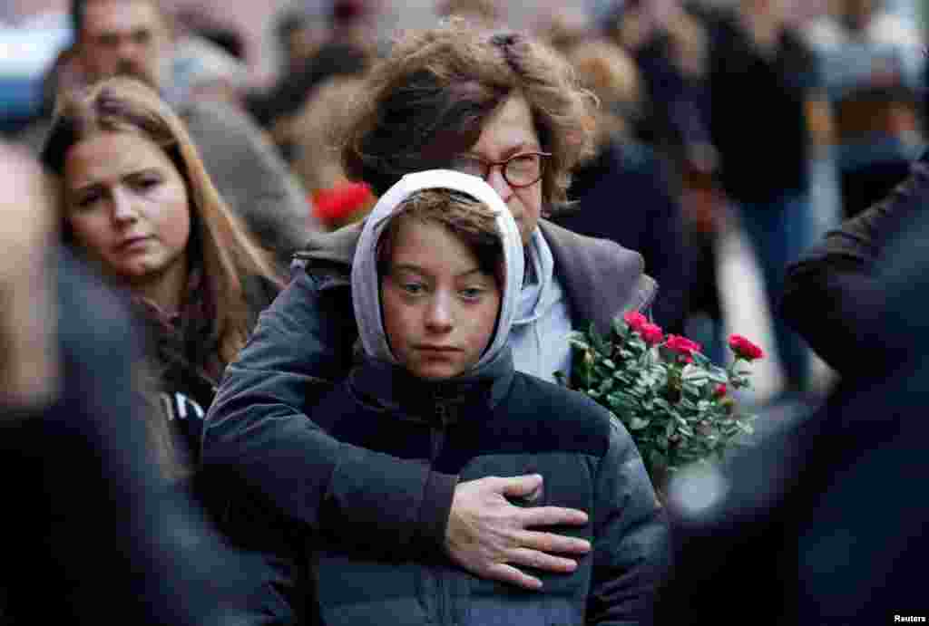 People mourn outside the synagogue in Halle, Germany, a day after two people were killed in a shooting.