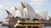 Sebuah kapal feri berlayar melewati Opera House di Sydney, Australia, Selasa, 6 April 2021. Australia yang kaya batu bara mengungkapkan target nol emisi bersih pada 2050. (Foto: AP)