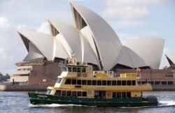 Sebuah kapal feri berlayar melewati Opera House di Sydney, Australia, Selasa, 6 April 2021. (Foto: AP)