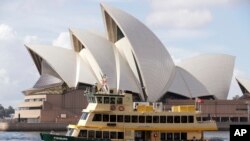 Sebuah kapal feri berlayar melewati Opera House di Sydney, Australia, Selasa, 6 April 2021. Australia yang kaya batu bara mengungkapkan target nol emisi bersih pada 2050. (Foto: AP)