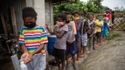 Aeta students queue to sanitize their hands before a session at the makeshift rickshaw learning center for Aeta community distance learning amid the COVID-19 pandemic, in Porac, Pampanga, Philippines, October 12, 2020.