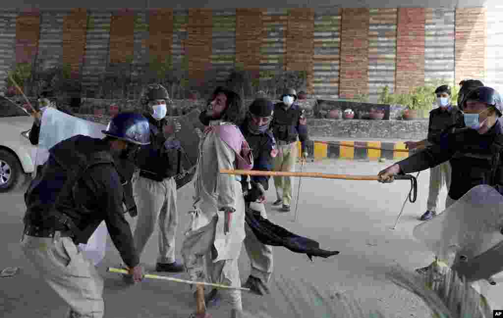 Police officers hit a supporter of Tehreek-e-Labiak Pakistan, a radical Islamist political party, before detain him in a protest against the arrest of their party leader, Saad Rizvi, in Peshawar.