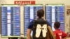 Passengers check the departure board at Miami International Airport, Sept. 7, 2017. 