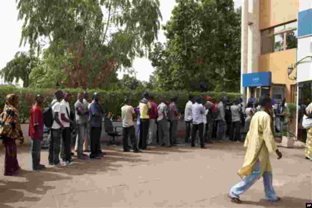 People stand in line outside a bank in Bamako, Mali Friday, March 30, 2012.