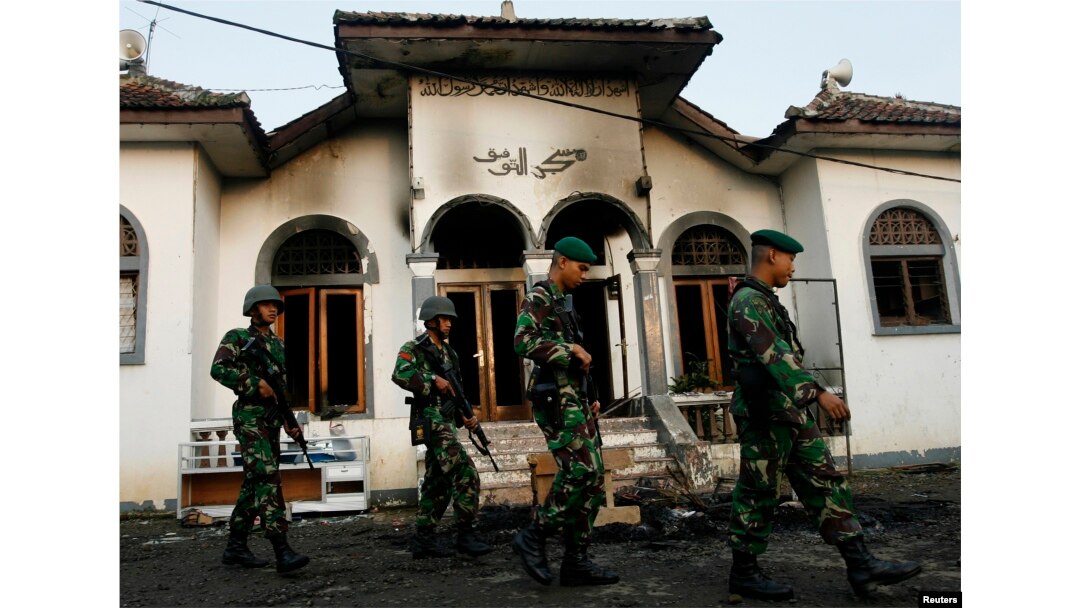 . Tentara berjalan melewati masjid pengikut Ahmadiyah yang dibakar massa di Desa Ciampea, Jawa Barat, 2 Oktober 2010.