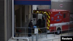 Nhân viên y tế làm việc tại cổng vào khu vực cấp cứu của Bệnh viện Methodist Hospital ở Trung tâm Y tế Texas trong lúc số ca nhiễm virus corona tăng vọt ở Houston, bang texas, ngày 8 tháng 7, 2020.