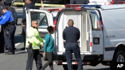 A woman, center, is taken into custody on Capitol Hill in Washington, March 29, 2017. Police say a driver struck a U.S. Capitol Police cruiser near the U.S. Capitol and was taken into custody. 