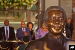 FILE - South African President Jacob Zuma, second from left behind a bust of former president Nelson Mandela, prepares to give a national address in Cape Town, June 17, 2014.