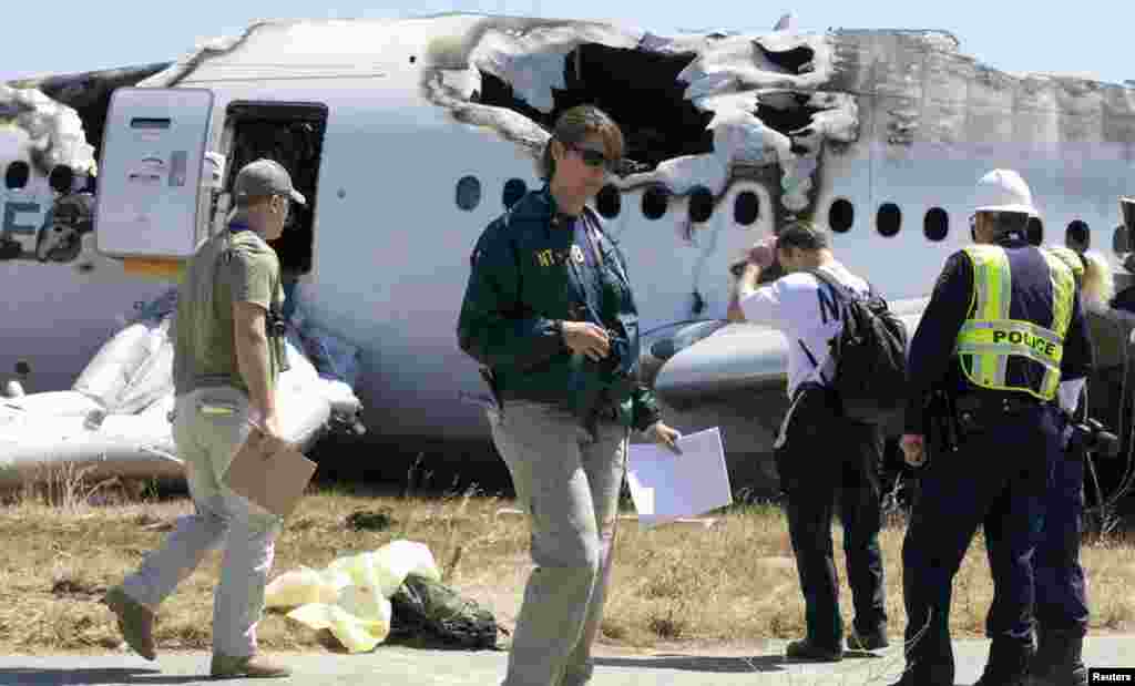 Des enquêteurs américains sur les lieux de l'accident, le 7 juillet 2013