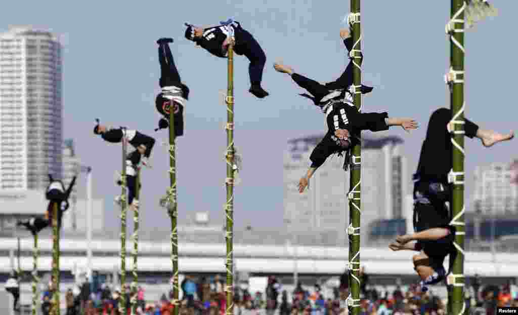 Members of the Edo Firemanship Preservation Association display their balancing skills atop bamboo ladders during a New Year demonstration by the fire brigade in Tokyo, Japan.