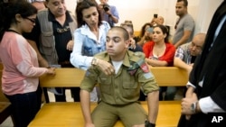 FILE - Israeli solider Elor Azaria sits inside an Israeli military court in Tel Aviv, Israel, in an April 18, 2016, photo. If convicted, Azaria faces up to 20 years in prison.