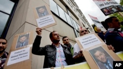 Men hold protest posters in front of a court to support the release of the journalist Ahmed Mansour in Berlin, Germany, June 21, 2015.