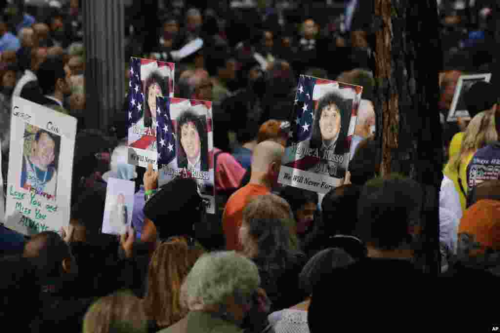 Orang-orang mengusung foto-foto kenangan dalam upacara memperingatu 17 tahun serangan teroris terhadapa Amerika Serikat, 11 September 2018, di New York.