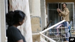 An Ethiopian maid, right, chats with another maid from Sri Lanka, left, as they stand on balconies in Beirut (File Photo)