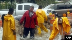 Nhiều người lấy bao cát chặn nước lũ từ Bayou Barataria tràn vào nhà cửa tại thị trấn Jean Lafitte ngay bên ngoài New Orleans, thứ Bảy, 3/9/2011