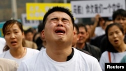 Thân nhân cách hành khách Trung Quốc trên chuyến bay MH370 phẫn nộ hô khẩu hiệu và khóc trong lúc tuần hành đến Đại sứ quán Malaysia tại Bắc Kinh, ngày 25/3/2014.