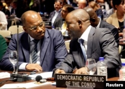 FILE - Democratic Republic of Congo's Parliament delegators Maitre Mbuku (R) and Leonard Okitundu talk together during the 128th Assembly of the Inter-Parliamentary Union (IPU) and Related Meetings in Quito March 23, 2013.