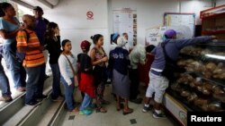 Los venezolanos hacen fila para comprar pan en una panadería administrada por el gobierno en Caracas.