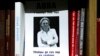 A portrait of investigative reporter Anna Politkovskaya with the words 'the killers are still at large' is displayed on a bookshelf in the offices of the Novaya Gazeta newspaper in Moscow, Russia, Oct. 7, 2021.