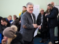 Communist party candidate Pavel Grudinin prepares to cast his ballot in the presidential election at the Lenin state farm outside Moscow, Sunday, March 18, 2018.