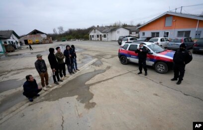 在塞尔维亚贝尔格莱德以北50公里的塞尔维亚北部城镇兹雷尼亚宁附近，在一家中国汽车轮胎工厂建筑工地打工的越南工人和塞尔维亚警察站在工房旁。（2021年11月18日）