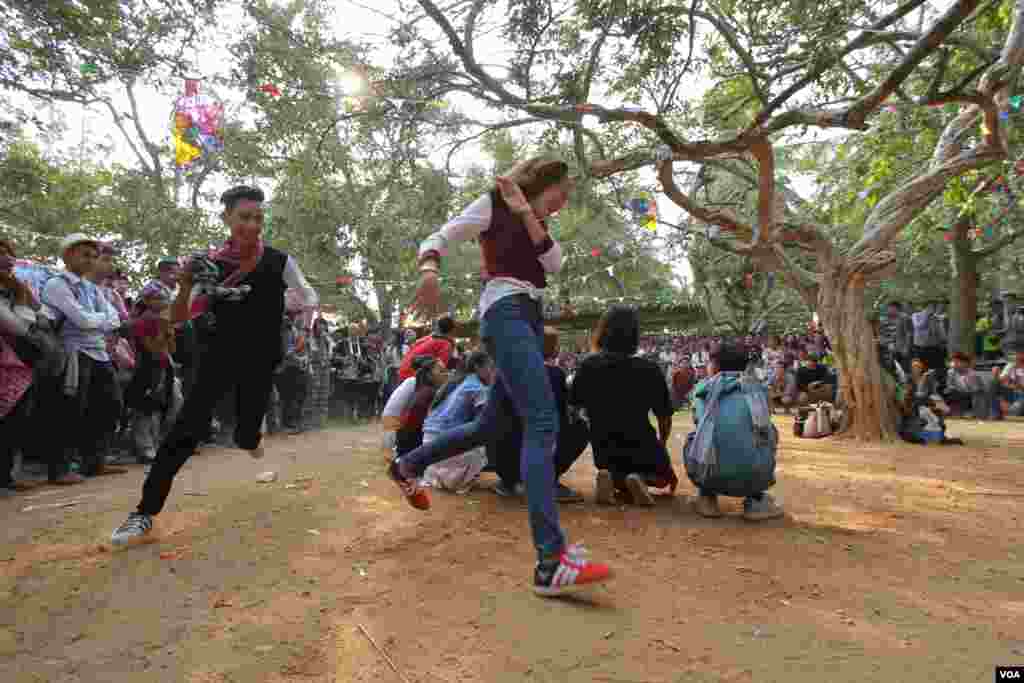 យុវជនម្នាក់ដេញយុវតីម្នាក់ទៀតលេងល្បែងលាក់កន្សែង ក្នុងពិធីមួយដើម្បីប្រារព្ធចូលឆ្នាំខ្មែរនៅវត្តជ្រោយអំពិលខ័ណ្ឌច្បារអំពៅរាជធានីភ្នំពេញកាលពីថ្ងៃសៅរ៍ទី០៩ខែមេសានេះ។ ប្រជាជនខ្មែរប្រារព្ធពិធីបុណ្យចូលឆ្នាំខ្មែរចាប់ពីថ្ងៃទី ១៣ដល់ទី១៦ ខែមេសាឆ្នាំ២០១៦នេះ នៃឆ្នាំវក សត្វស្វា។ (ឡេង ឡែន/VOA)