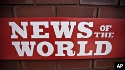 A News of the World sign is seen by an entrance to a News International building in London, Wednesday, July 6, 2011