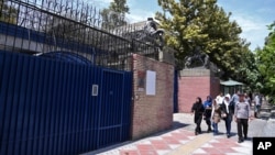 Pedestrians walk past the main gate of British Embassy in Tehran, Iran, Aug. 22, 2015. 