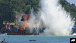 FILE - In this image made from video, an illegal fishing vessel that was seized by Indonesia’s navy is sunk in the waters off Pangandaran, West Java, Indonesia, March 14, 2016. 