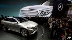 FILE - In this April 20, 2014 file photo, visitors look at the latest model from Mercedes at an auto show in Beijing.