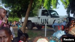 FILE - A U.N. truck drives past displaced South Sudanese families resting in a camp for internally displaced people in the United Nations Mission in South Sudan compound in Tomping, Juba, July 11, 2016. 
